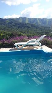 a white chair sitting next to a swimming pool at Cabañas La Fortaleza in La Caldera