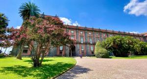 ein großes Backsteingebäude mit einem Baum davor in der Unterkunft La Casa del Bosco - Unique two floors House with garden in Neapel