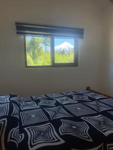 a bedroom with a bed with a view of a mountain at Casa peumayen in Puerto Varas