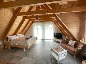 1 dormitorio con cama, sofá y TV en SEENLANDHOF en Senftenberg