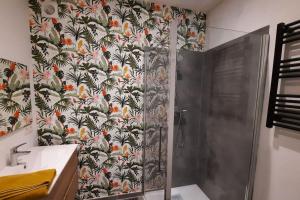 uma cabina de duche na casa de banho com papel de parede floral em Studio a Ciney em Ciney