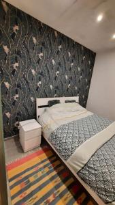 a bedroom with a bed and a patterned wall at Studio a Ciney in Ciney