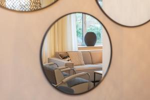 espejo que refleja una sala de estar con sofá y sillas en Appartement in Marina Kamperland, en Kamperland