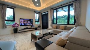 sala de estar con sofá y TV en 莫民宿 MO Homestay, en Yuanshan