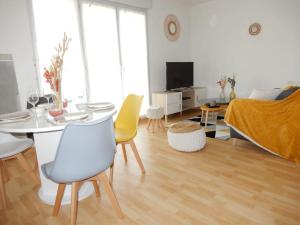 a living room with a table and yellow chairs at Bienvenue au Cocon d'Alyssa in Langon