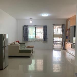 uma sala de estar com um sofá e um frigorífico em Min&Me House Pattaya em Nong Prue