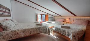 Habitación con 2 camas y una silla. en Casetta all'Abetone Jacopo e Sabrina, en Abetone