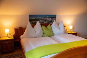 a bedroom with a green and white bed with two lamps at Ferienwohnung Seifterhof in Sankt Andrä im Lungau