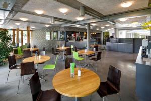 a restaurant with tables and chairs in a cafeteria at Backpackers Villa Sonnenhof - Hostel Interlaken in Interlaken