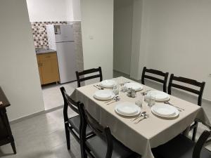 mesa de comedor con mantel y sillas blancas en FIA House, en Ždanec