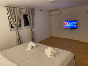 a bedroom with a bed with two white towels on it at FIA House in Ždanec