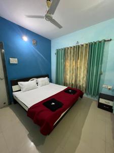 a bedroom with a large bed with a red blanket at iIRA Stays-Awas Beach Resort - Pet Friendly in Alibaug