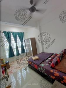 een slaapkamer met een bed en een plafondventilator bij TIARA @ CASA KAYANGAN (MUSLIM HOMESTAY) in Ipoh