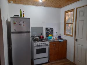 een keuken met een wit fornuis en een koelkast bij Domos y cabañas Monte Patria in Monte Patria