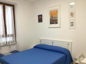 um quarto com uma cama azul e uma janela em DomuSumma em Roma