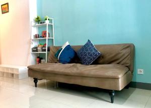 a brown couch in a living room with pillows on it at Benson Tower Surabaya Apartment 2BR by Le Ciel Hospitality in Lontar