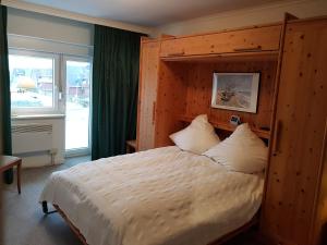 Schlafzimmer mit einem großen Bett mit einem Kopfteil aus Holz in der Unterkunft Seestern in Hörnum