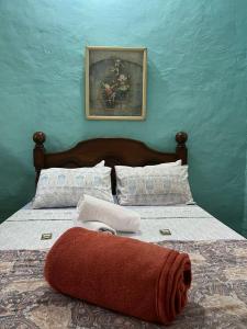 - une chambre avec un lit et une serviette rouge dans l'établissement Recanto das Margaridas, à Ilhabela