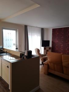 een kamer met een keuken en een woonkamer met een bank bij Ferienhaus HCR Grimmen in Grimmen