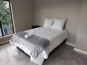 Pretoria的住宿－Alcade Ekhaya，卧室配有一张带白色床单和枕头的大床。