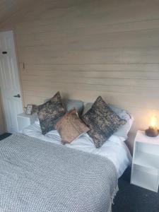 een bed met kussens in een kamer bij The Gull & Puffin Cresswell in Cresswell