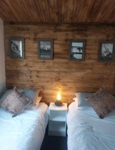 a bedroom with two beds and a table with a lamp at The Gull & Puffin Cresswell in Cresswell