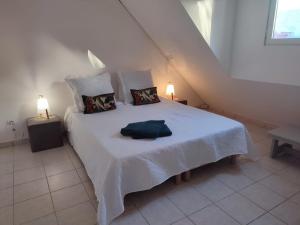 - une chambre avec un grand lit blanc et deux lampes dans l'établissement Charmante villa avec accès direct à la mer, à Sainte-Rose