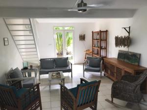uma sala de estar com cadeiras, um sofá e uma mesa em Charmante villa avec accès direct à la mer em Sainte-Rose