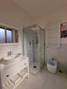 a bathroom with a sink and a shower and a toilet at L'Elisir Home in Caserta
