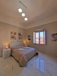 a bedroom with a bed and a window and two lamps at L'Elisir Home in Caserta