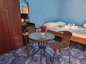 een kamer met een tafel, 2 stoelen en een bed bij หอพักโชคอนันต์ in Chiang Rai
