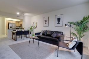 a living room with a black couch and a table at Condo with Gym and Pool in Pentagon City 8min to DCA in Arlington