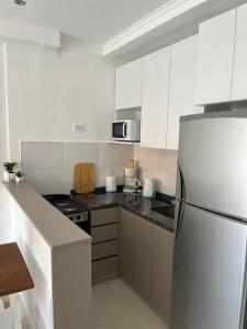 cocina blanca con nevera y fogones en Departamento de 1 dormitorio. en Corrientes