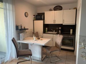 eine Küche mit einem Tisch, Stühlen und einer Theke in der Unterkunft Ferienvilla Waldstraße Wohnung Nr. 4 in Bansin