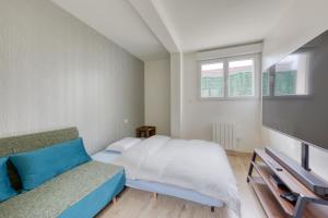 sypialnia z łóżkiem, kanapą i oknami w obiekcie Silver&Gold House Pro & Family w mieście Ivry-sur-Seine