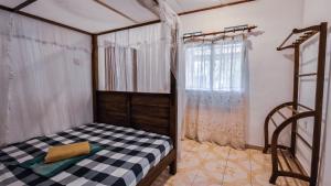 a bedroom with a bed with a black and white checkeredkered at Sun Set Sea Family House in Weligama