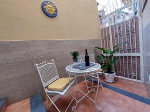 a table and chairs with a bottle of wine on it at Pied-à-terre81 in Acireale