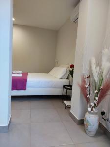 a bedroom with a bed and a vase with flowers at Pied-à-terre81 in Acireale