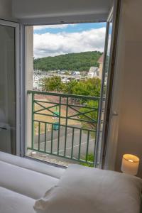 a bedroom with a bed and a window with a view at 2 pièces Port Cabourg - 2 à 4 personnes - 34 m2 - Balcon - Vue Port - Proche Plage in Dives-sur-Mer