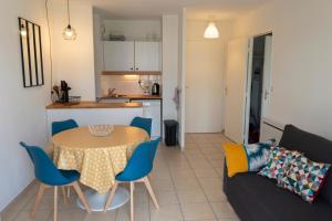 uma sala de estar com uma mesa e um sofá em 2 pièces Port Cabourg - 2 à 4 personnes - 34 m2 - Balcon - Vue Port - Nouveau sur Booking ! em Dives-sur-Mer