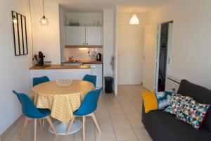 a living room with a table and a couch at 2 pièces Port Cabourg - 2 à 4 personnes - 34 m2 - Balcon - Vue Port - Proche Plage in Dives-sur-Mer +22 photos