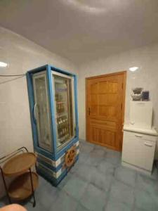a room with a blue cabinet and a refrigerator at Haus Kathrin in Zecherin
