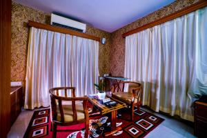 um quarto com uma mesa e duas cadeiras e uma janela em THE FAME HOTEL em Jādabpur
