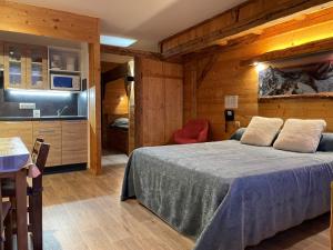 1 dormitorio con 1 cama en una habitación de madera en Hotel Le Very, en Les Saisies