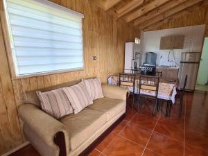 a living room with a couch and a kitchen at Cabaña en Bahía Murta, equipada para 4 personas in Bahía Murta