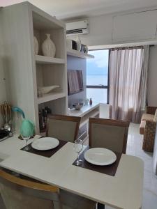 una cocina con mesa y sillas con platos y copas de vino en Flat Tropical Executive en Manaos