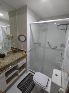 y baño con ducha, aseo y lavamanos. en Flat Tropical Executive en Manaos