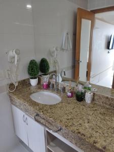 encimera con lavabo y espejo en Flat Tropical Executive en Manaos