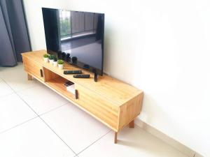TV sobre una mesa de madera en ●OIM11●Lovely Condo 3bedrooms with Facilities en Bayan Lepas