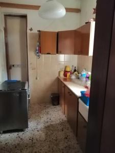 une cuisine avec des placards bruns et un comptoir blanc dans l'établissement "Villa Isola di MOTHIA" Piccolo appartamento 5' dal mare e aeroporto Trapani, à Rilievo